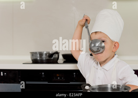 Dégustation de jeune chef soupe louche dans la cuisine Banque D'Images