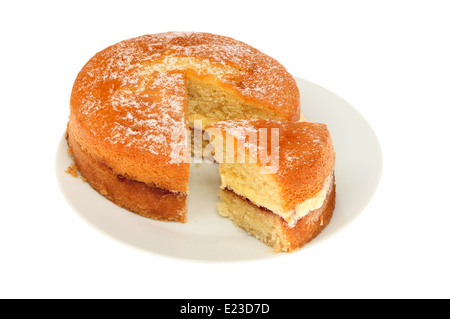 Victoria avec une tranche de gâteau éponge cut sur une assiette blanche contre isolés Banque D'Images