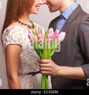 Couple dans l'amour avec un bouquet de tulipes sont proches les uns des autres. Se concentrer sur les tulipes. Banque D'Images