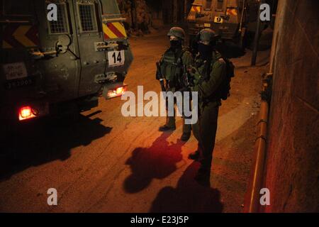 15 juin 2014 - Hébron, en Cisjordanie, territoire palestinien - une zone de patrouille de soldats israéliens dans la ville cisjordanienne de Hébron le 15 juin 2014, dans leur recherche de trois adolescents qui ont disparu à proximité d'une colonie en Cisjordanie. Les jeunes, dont un est également titulaire d'un passeport américain, on pense qu'ils ont été enlevés le 12 juin 2014 par le bloc Etzion entre Bethléem et Hébron, aurait été alors que l'auto-stop. Israël considère l'Autorité palestinienne responsable pour le retour des trois adolescents kidnappés par une ''organisation terroriste, '' Le Premier Ministre Benjamin Netanyahu a dit ( Banque D'Images