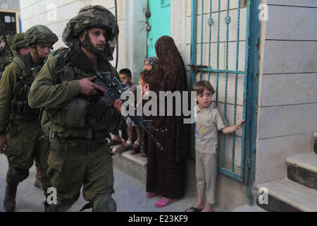 Hébron, en Cisjordanie. 15 Juin, 2014. Patrouille de soldats israéliens dans la ville de Cisjordanie d'Hébron pour recherche de trois adolescents juifs disparus le 15 juin 2014. Le Premier ministre israélien Benjamin Netanyahu a déclaré que la jeunesse juive ont été enlevés en Cisjordanie par une organisation terroriste. Credit : Mamoun Wazwaz/Xinhua/Alamy Live News Banque D'Images