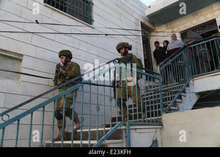 Hébron, en Cisjordanie. 15 Juin, 2014. Patrouille de soldats israéliens dans la ville de Cisjordanie d'Hébron pour recherche de trois adolescents juifs disparus le 15 juin 2014. Le Premier ministre israélien Benjamin Netanyahu a déclaré que la jeunesse juive ont été enlevés en Cisjordanie par une organisation terroriste. Credit : Mamoun Wazwaz/Xinhua/Alamy Live News Banque D'Images