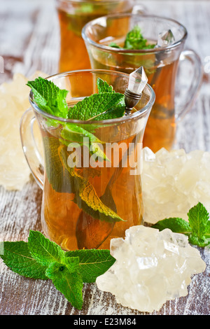 Thé turc traditionnel avec de la menthe fraîche et brun clair ou sucre nabot. Focus sélectif. Banque D'Images