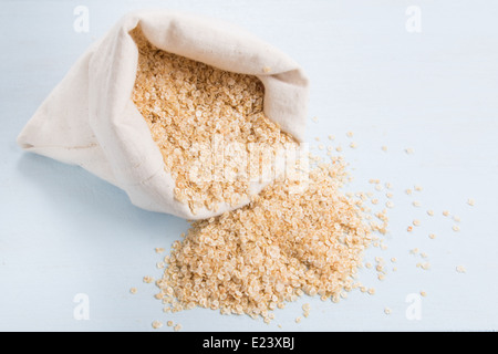 Les flocons de quinoa dans un sac de crème sur un fond bleu pâle (2 de 18) Banque D'Images