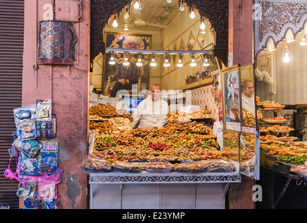 Vente de pâtisseries homme boutique ouverte sur la rue à la place Jemaa el-Fna, la médina de Marrakech, Maroc Banque D'Images