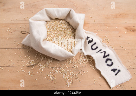 Les graines de quinoa dans un sac de crème avec une étiquette sur une planche en bois (21 de 24) Banque D'Images