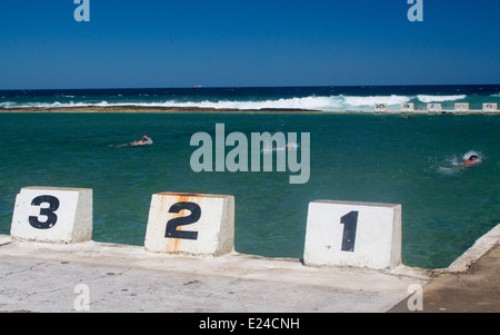 Merewether Ocean Baths Newcastle New South Wales Australie Lane des marqueurs avec les nageurs en piscine avec l'océan Pacifique au-delà Banque D'Images