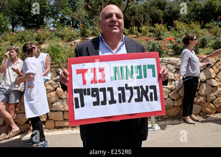 Jérusalem, Israël. 16 Juin, 2014. MK AFOU AGBARIA (Hadash) pose pour les caméras tenant un signe de protestation. Médecins pour les droits de l'homme Israël) ont organisé une manifestation en face de la Knesset pour protester contre une loi par le gouvernement en cours afin que la force de l'alimentation rapide de la faim des prisonniers palestiniens en grève. PHR revendiquer quelques 80 prisonniers sont hospitalisés menottés à leur lit dans les hôpitaux israéliens après plus de 50 jours de grève de la faim. Credit : Alon Nir/Alamy Live News Banque D'Images