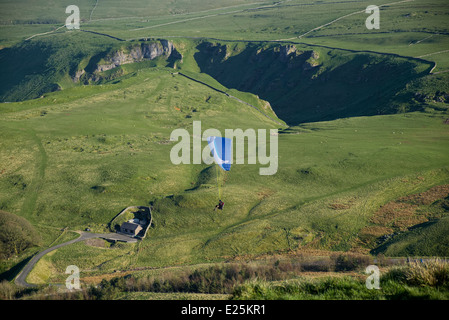 Parapente survole Treak Cliff cavern près de Castleton dans le parc national de Peak District Derbyshire, Angleterre Banque D'Images