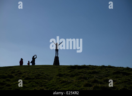 Personne debout sur un pilier de triangulation avec les bras tendus dans le Derbyshire Peak District en Angleterre Banque D'Images