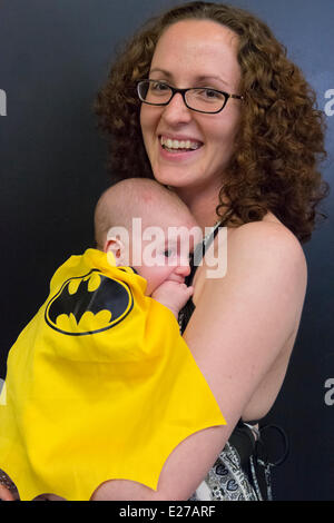 Garden City, New York, États-Unis - 14 juin 2014 - DANA MONTANO HARITOS tient ses deux mois à fils habillé en bébé BAT, portant une cape noire et jaune bat et costume, à l'Éternel Con, Pop Culture Expo annuelle, tenue au berceau de l'Aviation Museum sur Long Island. Credit : Ann E Parry/Alamy Live News Banque D'Images