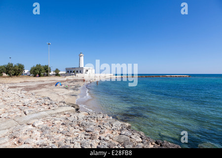 Phare blanc sur fond de ciel bleu avec plage rocheuse à une baie à San Cataldo, Pouilles, Salento, dans le sud de l'Italie Banque D'Images