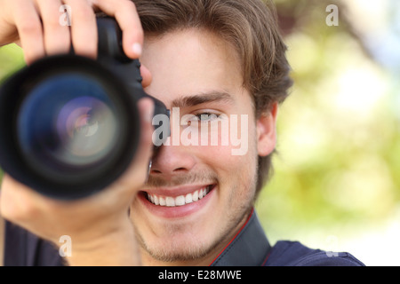 Vue de face d'un photographe la photographie avec un reflex numérique montrant avec un fond vert Banque D'Images