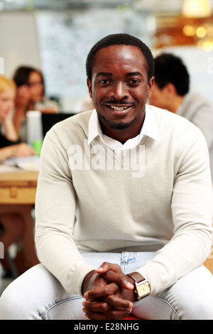 Portrait of smiling businessman assis devant des collègues Banque D'Images