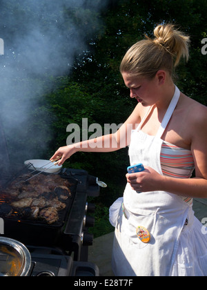 La cuisson à Femme d'un barbecue. Banque D'Images