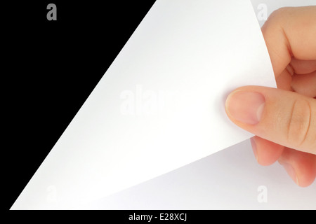 Feuille de papier vierge avec Main sur fond noir Banque D'Images