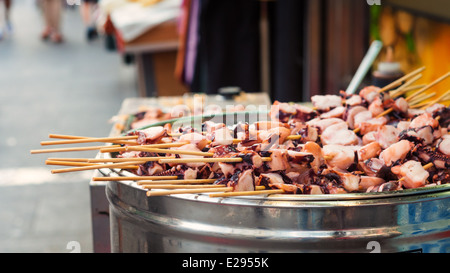 Brochettes de calmars sur un grill au streetmarket à Insadong, Séoul. Banque D'Images