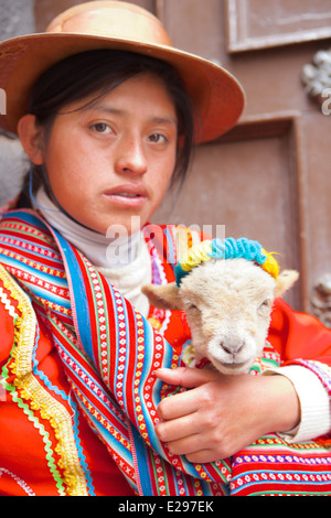 Le portrait d'une jeune fille Quechua dans leur costume traditionnel tenant un agneau dans Cusco, dans les Andes, le Pérou, Amérique du Sud Banque D'Images