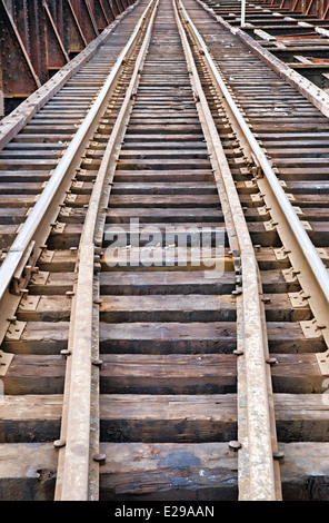 Un ensemble de rails de chemin de fer menant à la distance sur un pont. Banque D'Images