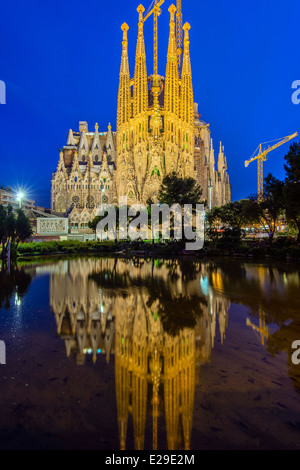 Vue nocturne de l'église Sagrada Familia reflétée dans un étang, Barcelone, Catalogne, Espagne Banque D'Images