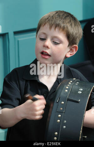 L'Irlande, le comté de Clare, Milltown Malbay, jeune garçon jouant le bodhran, le tambour traditionnel irlandais Banque D'Images