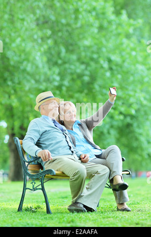 D'âge mûr en tenant avec selfies téléphone cellulaire dans le parc Banque D'Images