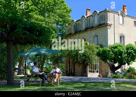 La France, l'Hérault, Saint Aunes, Château les Mazes domaine, couple assis sur des chaises dans un jardin en face d'une maison, les propriétaires Banque D'Images