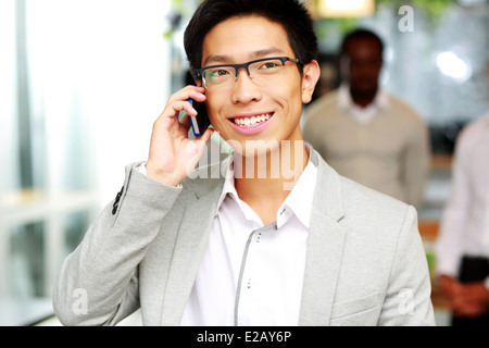 Portrait of a happy couple sur le smartphone devant des collègues Banque D'Images