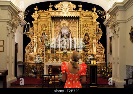 Espagne, Andalousie, Séville, Triana, intérieur doré de la chapelle de l'Estrela femme priant et portant une robe de gitane Banque D'Images