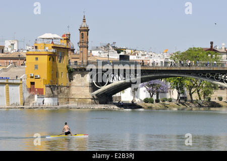 Espagne, Andalousie, Séville, Triana, l'homme sur son radeau sur le fleuve Guadalquivir, pont Isabel II Banque D'Images