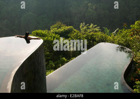 L'INDONÉSIE, Bali, Ubud, Buahan Payangan, Ubud Hanging Gardens hotel group Orient-Express une jeune femme les bras tendus en arrière, d'une piscine à débordement donnant sur la jungle au lever du soleil Banque D'Images