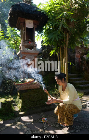 L'INDONÉSIE, Bali, Tabanan, hôtel Puri Taman Sari, femme de l'encens et d'offrir des offrandes de la matinée Banque D'Images