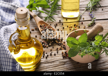 Les herbes et l'huile sur table en bois Banque D'Images