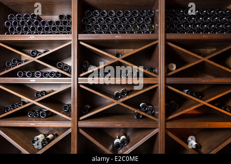 Cave à vin avec des bouteilles sur les étagères en bois Banque D'Images