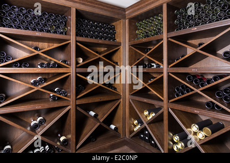 Cave à vin avec des bouteilles sur les étagères en bois Banque D'Images