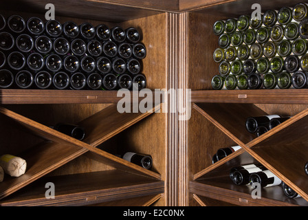 Cave à vin avec des bouteilles sur les étagères en bois Banque D'Images