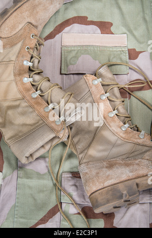 Vieilles chaussures de combat contre l'uniforme de camouflage desert Banque D'Images