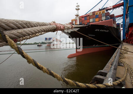 Le porte-conteneurs APL "Raffles" est considéré à l'Container Terminal Altenwerder (LTC) de Hamburger Hafen und Logistik AG (HHLA) au port de Hambourg avec porte-conteneurs OOCL 'Bruxelles' dans l'arrière-plan à Hambourg, Allemagne, 16 juin 2014. Les 1 400 mètres de long mur de quai est équipé de quatre amarres pour conteneurs de grande capacité. Plus de 80 véhicules à guidage automatique (AGV) sont à utiliser pour gérer le transport de conteneurs entre les lieux de stockage dans le centre de la borne et le récipient de l'eau pont à l'avant. L HHLA tient son assemblée générale le 19 juin 2014. Photo : CHRISTIAN CHARISIUS/dp Banque D'Images