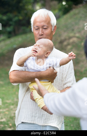 Les grands-parents asiatiques réconfortant crying baby grandson at outdoor Banque D'Images