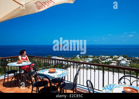 Italie, Sicile, îles Éoliennes, l'UNESCO, l'île de Stromboli, terrasse de café avec Ingrid îlot Strombolicchio en arrière-plan Banque D'Images