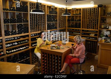 La France, l'Hérault, Béziers, place Jean Jaurès, un bar à vins et tapas Le chameau ivre, dégustation de jeunes femmes d'un verre de vin dans un débarras qui sert de la restauration Banque D'Images