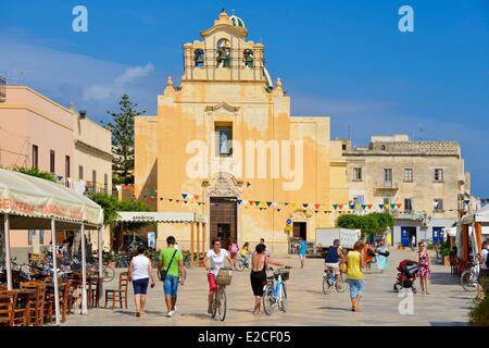 L'Italie, la Sicile, les îles Egades, île de Favignana, Piazza Madrice, les randonneurs à pied et en vélo sur une place pavée de l'église Madre Maria Immacolata du 18ème siècle dans l'arrière-plan Banque D'Images