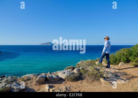 L'Italie, la Sicile, les îles Egadi, île de Favignana, Cala Rossa, l'homme sur un sentier de randonnée en face de l'île de Levanzo avec la mer Banque D'Images