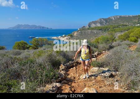 L'Italie, la Sicile, les îles Egadi, l'île de Levanzo, randonneur sur un sentier de montagne avec vue sur la mer et l'île de Favignana en arrière-plan Banque D'Images