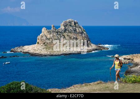 L'Italie, la Sicile, les îles Egadi, l'île de Levanzo, randonneur sur un sentier côtier avec vue sur mer avec Borgo Italia 77 île en arrière-plan Banque D'Images