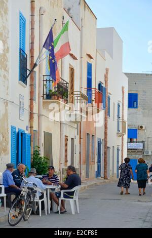 L'Italie, la Sicile, les îles Egadi, l'île de Marettimo, hommes jouant aux cartes à une table à l'ombre dans une rue piétonne Banque D'Images