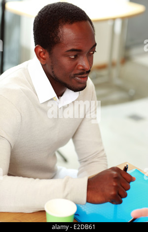Portrait de l'homme assis à la table Banque D'Images