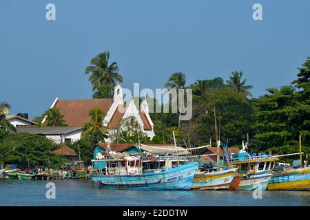 Sri Lanka Western Province district de Gampaha chalutiers colorés en bois de Negombo de pêche avec une église en arrière-plan Banque D'Images