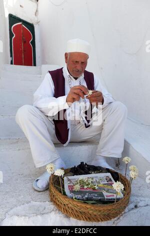 La Tunisie Sidi Bou Saïd vieil homme préparation bouquet de jasmin Banque D'Images