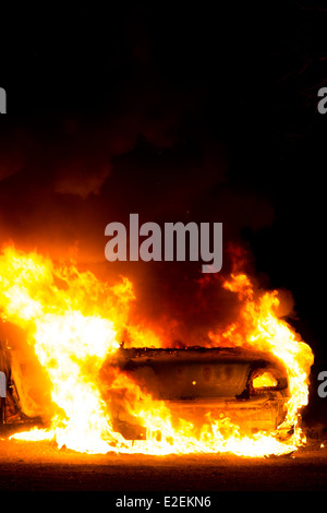 Une voiture en feu dans la nuit. Banque D'Images